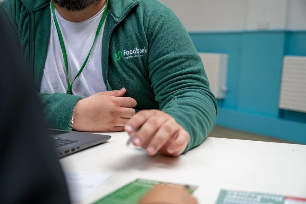Foodbank volunteer sat by computer