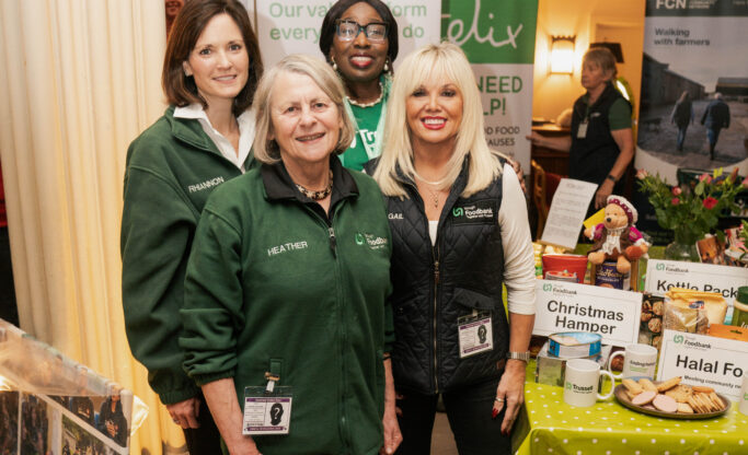 Sloug foodbank volunteers stand next to a table inside Windsor Castle
