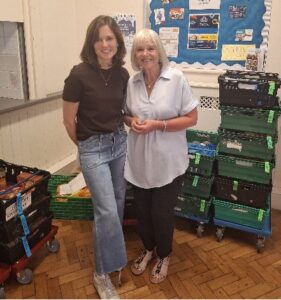 Two volunteers pose by some crates